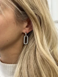 Ribbed Oval Hoop Earrings In Silver by SVNX