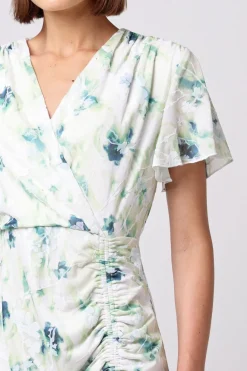 Wrap Ruched Mini Dress With Ruffle Hem In Green Floral Burnout Print by Angeleye